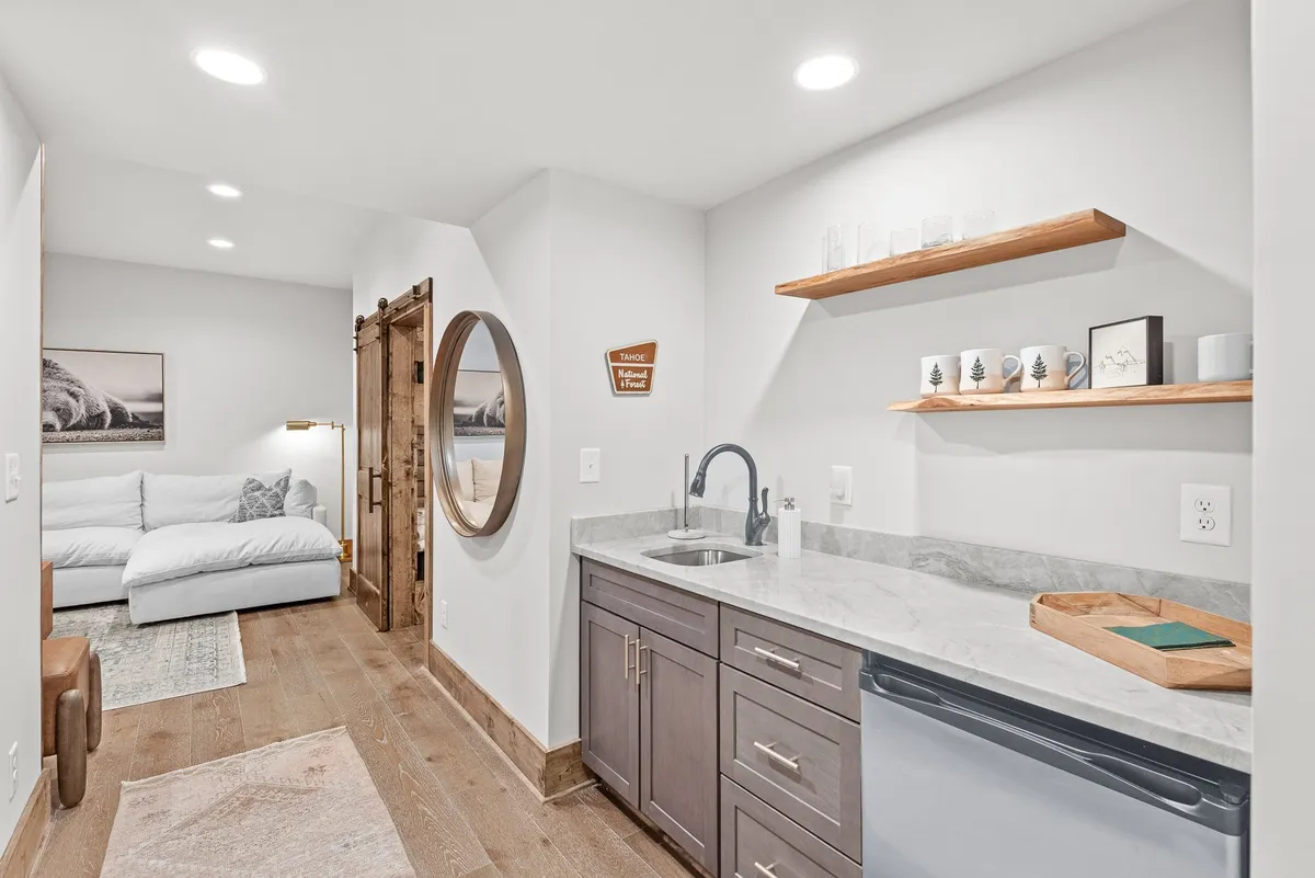 A cozy interior kitchenette area, featuring a small counter, couch, and decorative shelves. The space is intimate and inviting, perfect for preparing snacks and drinks, echoing the 'wet bar' function described in the section.